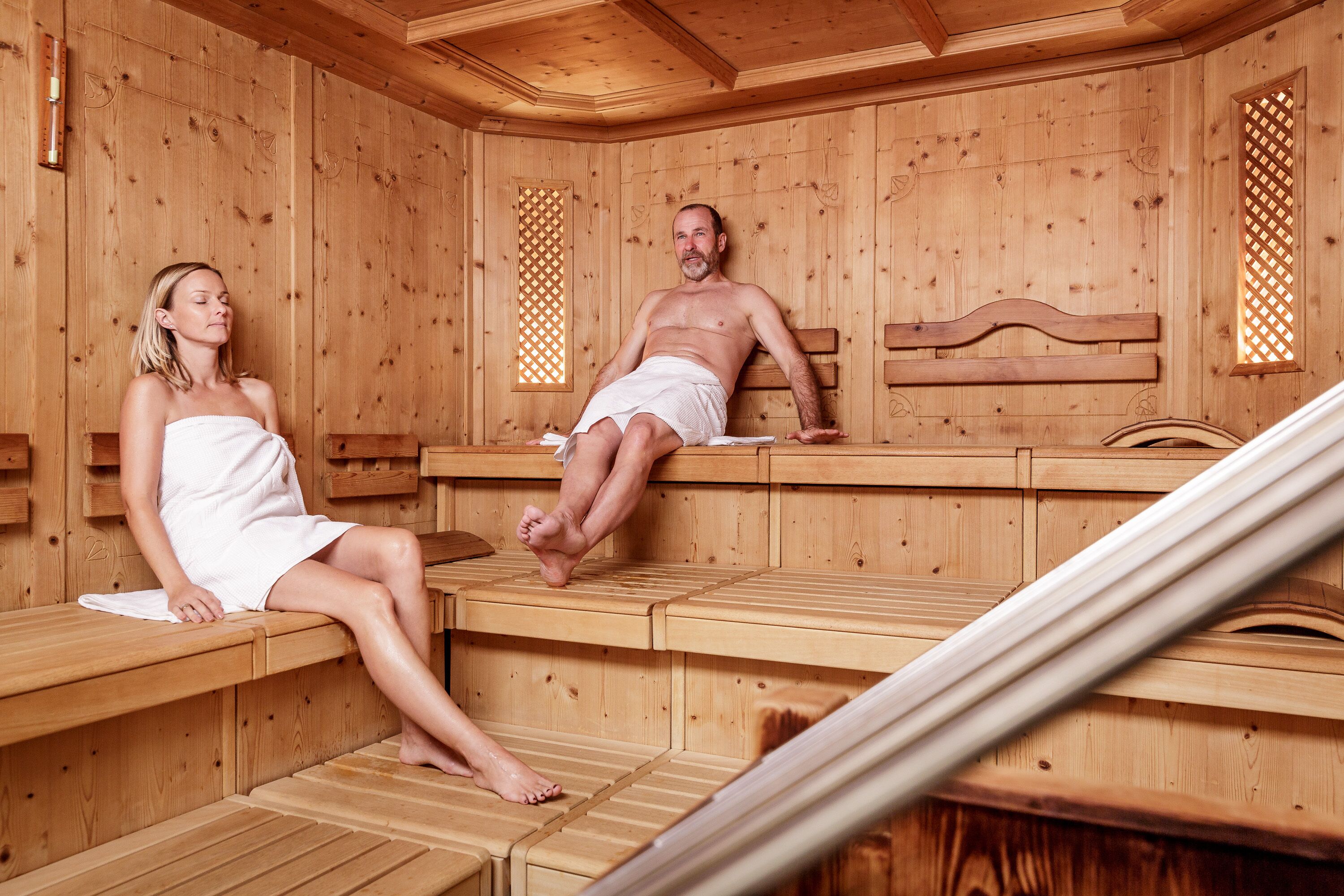 A wooden sauna with benches and a bench for a person to sit on.