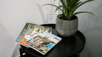Een tijdschrift op een tafel, met een potplant ernaast.