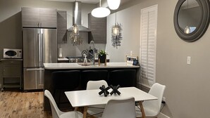 A modern kitchen with a built-in refrigerator, a microwave, and a coffee station. - Victorian Home in Denver's Hip Highlands Square (Denver)
