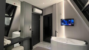 A modern bathroom with a freestanding bathtub, a large mirror, and a flat-screen TV mounted on the wall. - Loya Butik Otel - Bungalow (Çayeli)