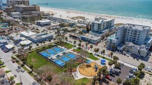 Vista aerea di una zona costiera con spiaggia, parcheggi e edifici.