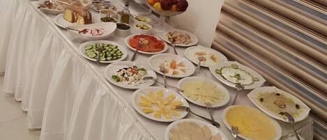 A buffet table with various dishes and a tea station.