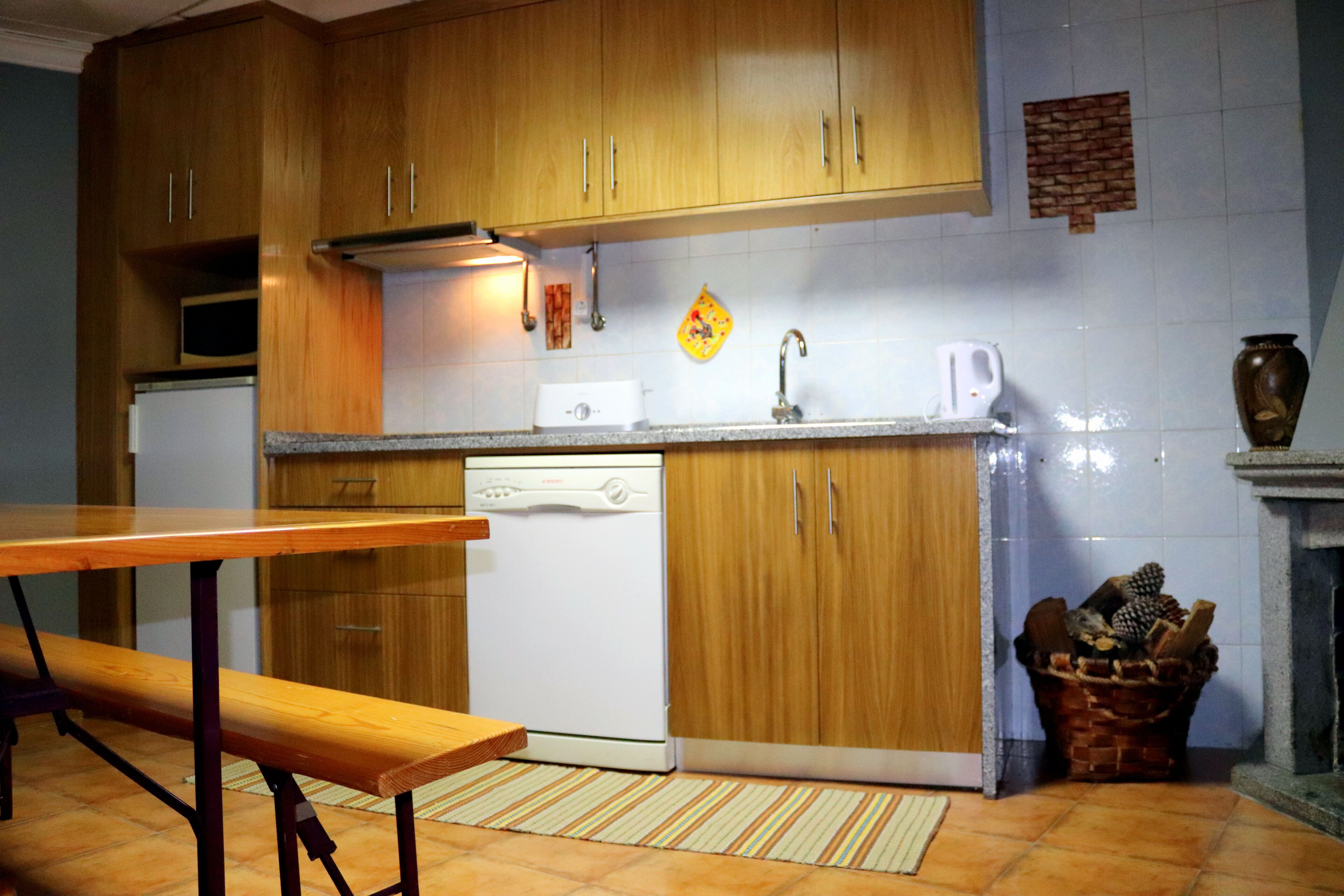 A kitchen with wooden cabinets, a dishwasher, a sink, and a tiled backsplash.