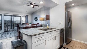 Una cocina moderna con una isla grande, electrodomésticos de acero inoxidable y un comedor con vistas.