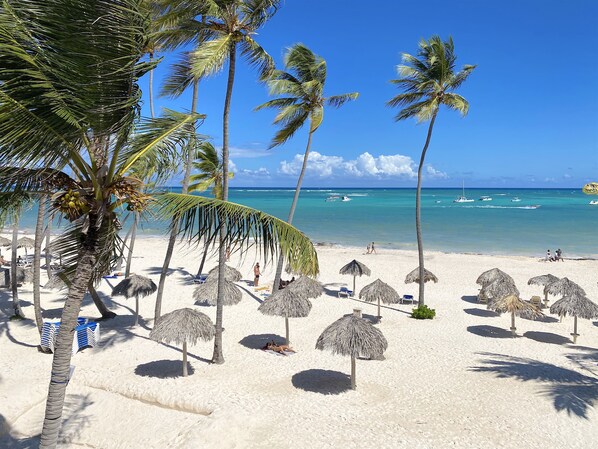 在海灘附近、白沙、躺椅、太陽傘