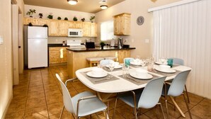 A compact kitchen with wooden cabinets, a microwave, and a refrigerator.