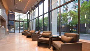 A spacious lobby with modern furniture and large windows offering views of the city. - LeGrant Suites Sukhumvit 11 Bangkok (Bangkok)