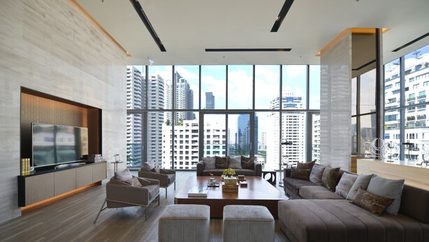 A modern living room with a large TV, comfortable seating, a coffee table, and a city view through large windows. - LeGrant Suites Sukhumvit 11 Bangkok (Bangkok)