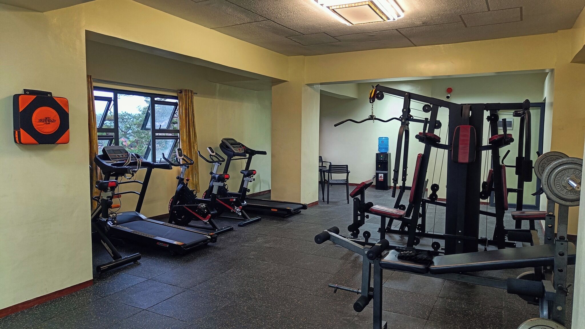 A gym with treadmills, elliptical machines, and weightlifting equipment.