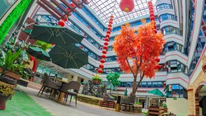 A multi-level atrium with indoor seating, a central tree, and red lanterns. - 456 Hotel (Baguio)