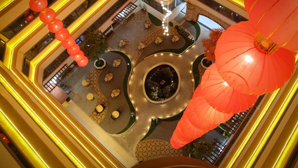 A multi-level atrium with a central fountain, surrounded by seating areas and illuminated by yellow lines. - 456 Hotel (Baguio)