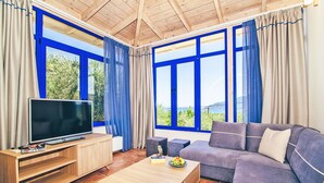 A modern living room with a large TV, a sofa, and a coffee table. - 3 Bedroom Villa, Agios Sostis, Zakynthos (Lithakia)
