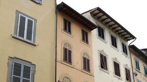A row of multi-story buildings with shop fronts, including a visible storefront with a sign reading "LORENZO SEGONI".