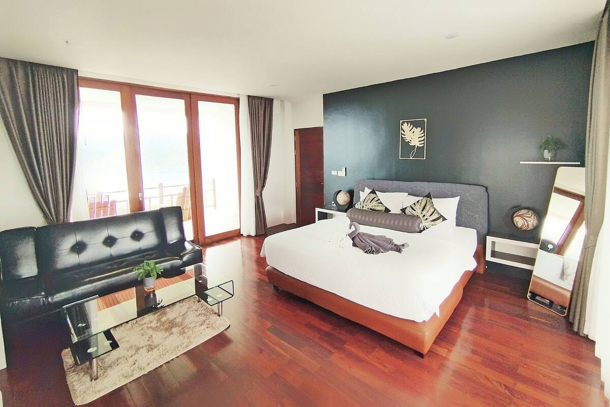 Un dormitorio moderno con una cama grande, un sofá y un escritorio.