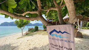 A beach sign for PP Mountain Beach with a chair for rent at 100 baht per day.
