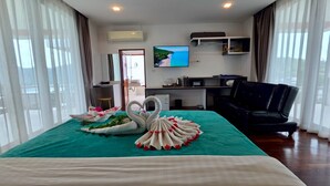A hotel room with a bed, a TV, a desk, and a chair.