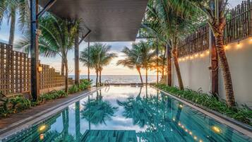 Alberca al aire libre, sombrillas en la alberca y camastros