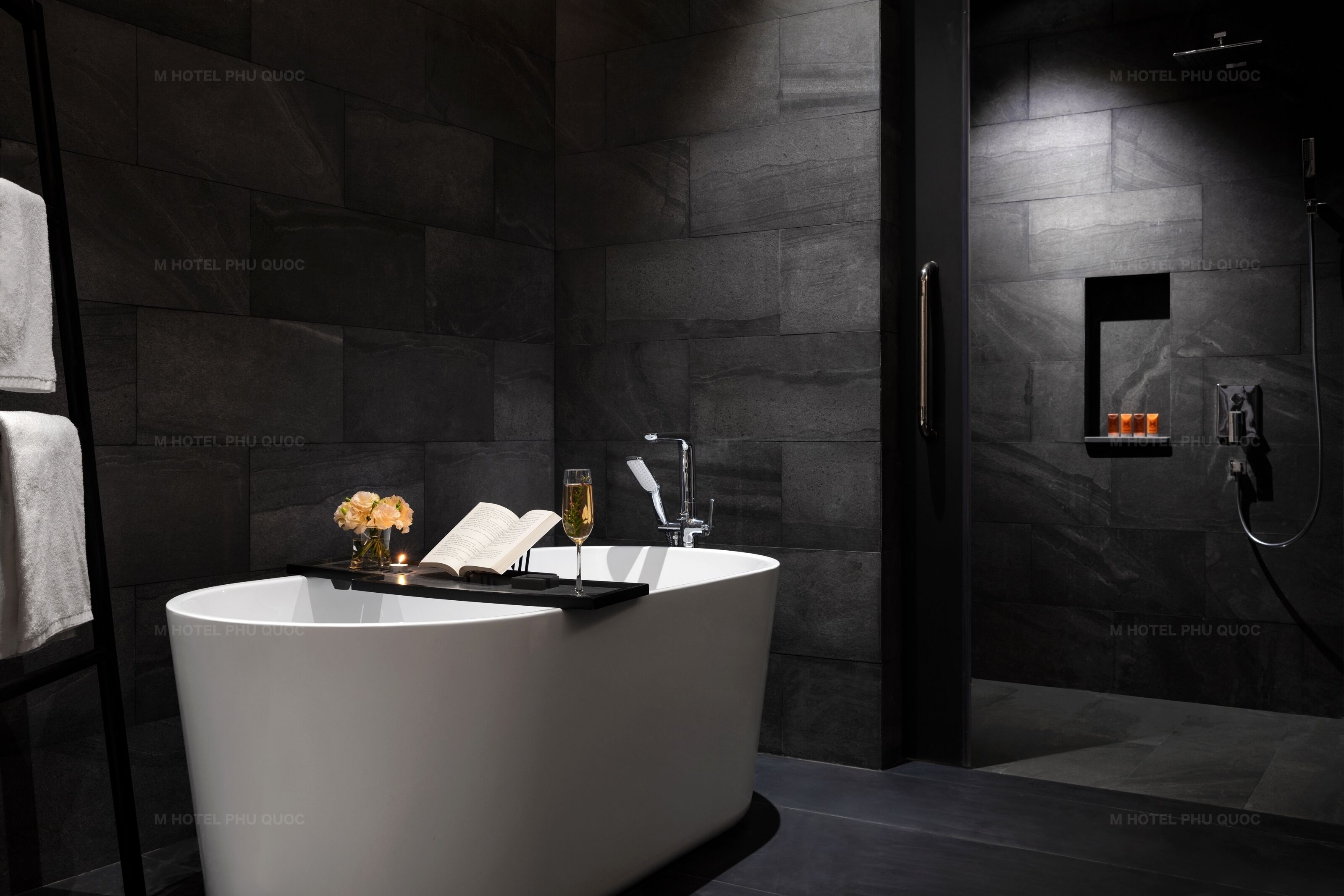 A modern bathroom with a freestanding bathtub, a glass shower enclosure, and a towel rack.