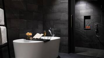 A modern bathroom with a freestanding bathtub, a glass shower enclosure, and a towel rack.