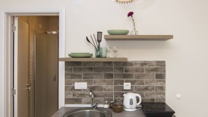 A modern kitchen with a built-in dishwasher, a stainless steel sink, and a brick backsplash. - Beo Green View (Belgrade)