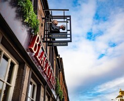 Un edificio con un cartel que dice "BLACKFRIARS" y "COMER, BEBER, DORMIR".