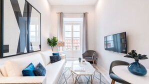 Ein modernes Wohnzimmer mit einer Couch, einem Couchtisch und einem Fernseher.