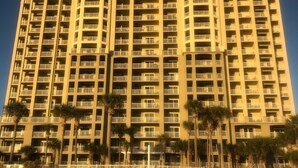 A high-rise hotel with multiple balconies and a beach view.