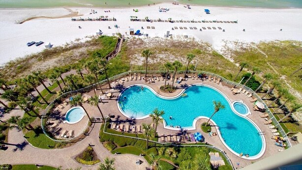 A resort with a large central pool, multiple smaller pools, and a beach area.