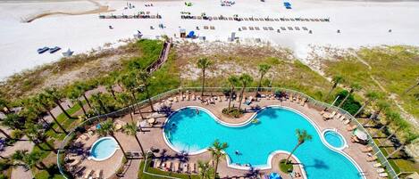 A resort with a large central pool, multiple smaller pools, and a beach area.
