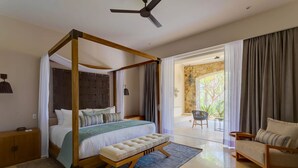 Uma cama de dossel com um banco, uma cadeira e vista para o exterior.