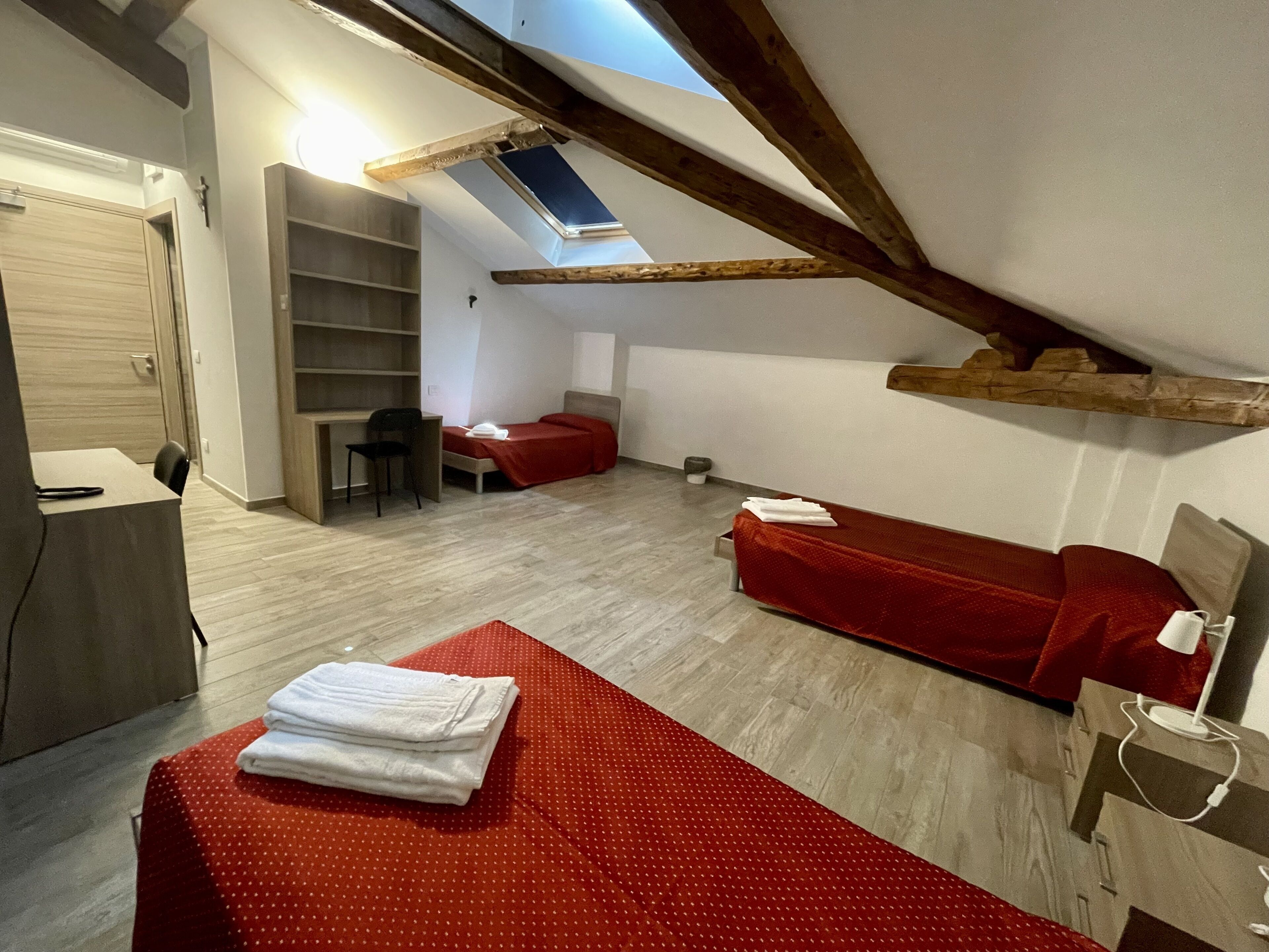 A compact room with a loft bed, a desk, and a chair.