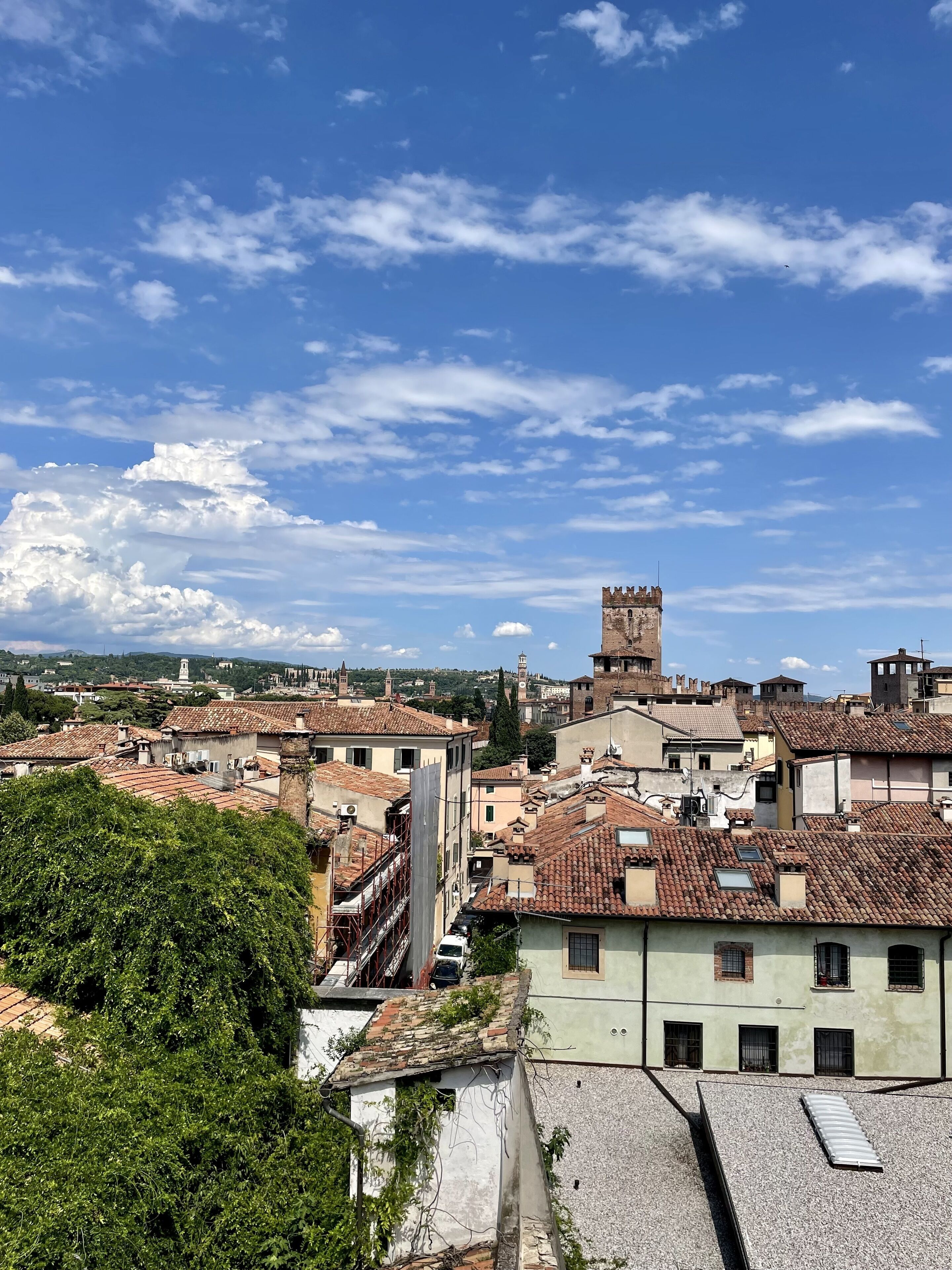 A historic town with terracotta-roofed buildings, a prominent tower, and a mix of old and new architecture.