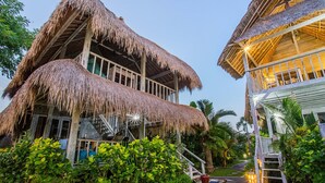 A two-story building with thatched roofs and a staircase leading to the upper level. - Naturale Villa (Lembongan Island)