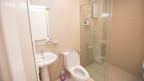 A modern bathroom with a glass-enclosed shower, a white sink, and a toilet.
