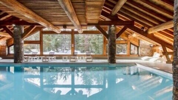 An indoor swimming pool with wooden beams and large windows. - Charming 3 rooms 3* residence Swimming pool, sauna, gym in Méribel Village (Méribel Village)