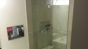 Ein modernes Badezimmer mit einer gläsernen Duschkabine, einer Toilette und einem Waschbecken.