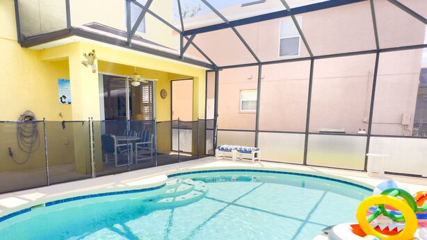 Una piscina interior con agua cristalina azul, un recinto de vidrio y un puesto de socorrista.