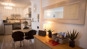 A compact kitchen with a dining area, a small refrigerator, a microwave, and a sink. There is a mirror above the mirror, a lamp, and a plant on the counter. - Ideal location for enjoying all of Tenby's attractions (Tenby)