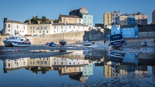 A waterfront with boats docked, buildings in the background, and a clear reflection in the water. - Ideal location for enjoying all of Tenby's attractions (Tenby)