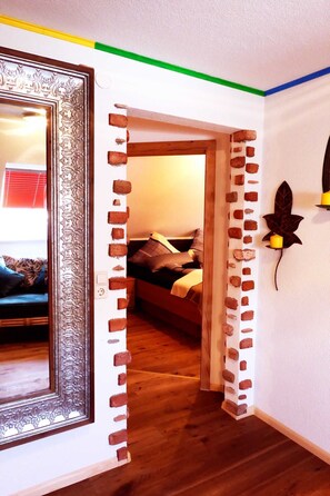 Una habitación con diseño de pared de ladrillo, una cama con almohadas y una hoja decorativa en la pared.