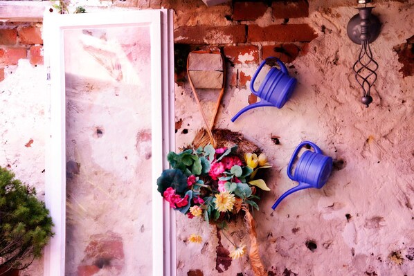 A brick wall with a window, a blue watering can, and a flower arrangement. - Taubergießen vacation rental - Vacation Home (Schwanau)