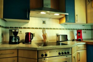 Een keuken met een fornuis, koffiezetapparaat en broodrooster.