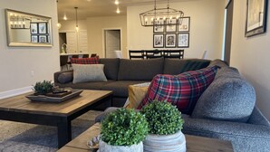A modern living room with a sectional sofa, a wooden coffee table, and two potted plants. - Spacious New Condo - Beautiful Views in the Heart of  Dillon. License# 651848101 (Dillon)