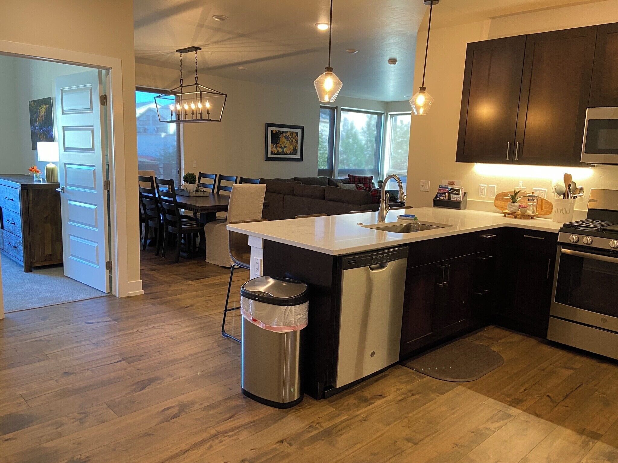 A modern kitchen with a central island, stainless steel appliances, and pendant lighting.