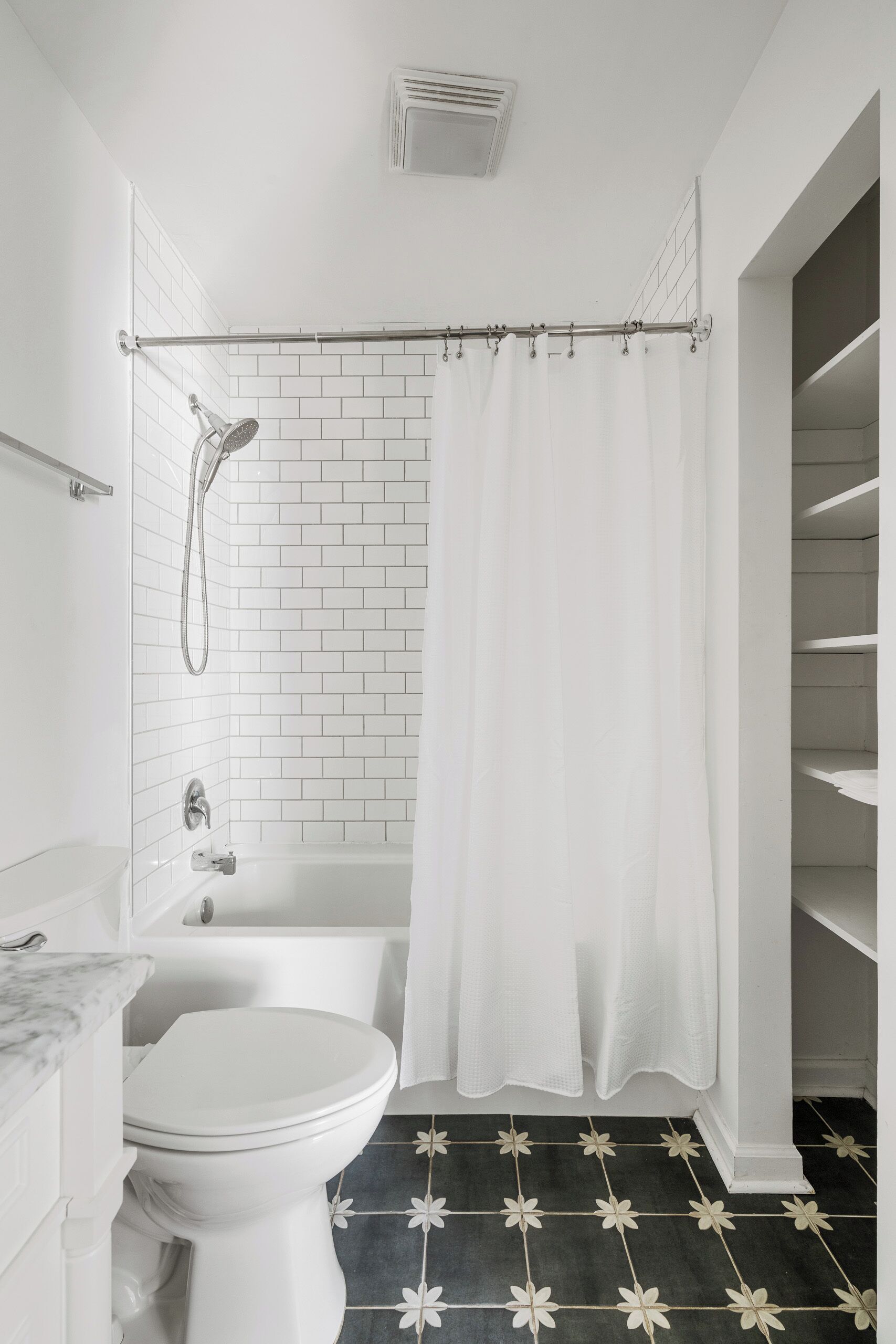 A bathroom with a white toilet, a bathtub, and a shower with a curtain.