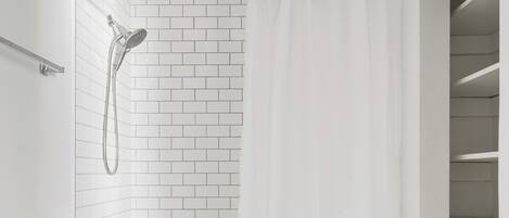A bathroom with a white toilet, a bathtub, and a shower with a curtain.