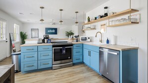 Eine moderne Küche mit blauen Schränken, Edelstahlgeräten und Holzarbeitsplatten.