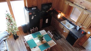 A compact kitchen with wooden cabinets, a refrigerator, a microwave, and a sink. - Cozy & Comfy with all the Views  (Gatlinburg)