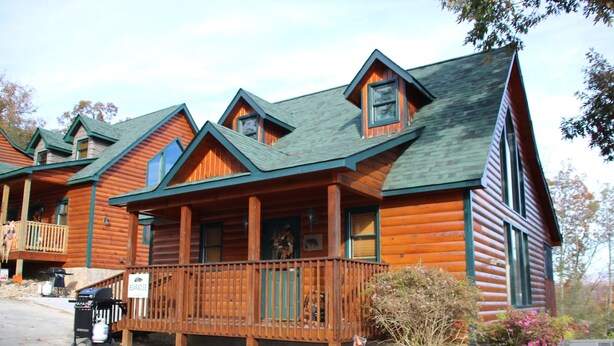 A log cabin with a balcony, a barbecue grill, and a sign indicating a restaurant. - Cozy & Comfy with all the Views  (Gatlinburg)