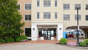 A multi-story building with a sign reading "GRAND VICTORIAN." - Grand Victorian on the Beach, Summer (Old Orchard Beach)